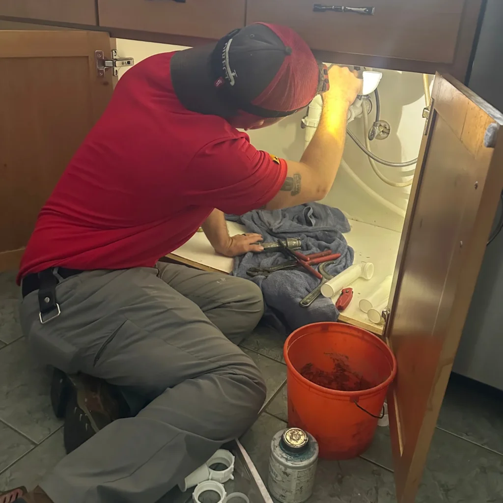 Plumber replacing pipes underneath sink